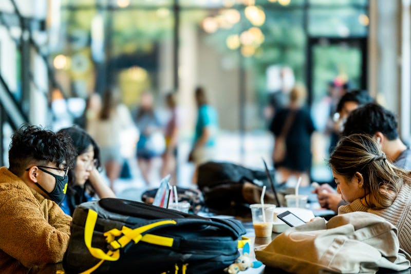 University students studying together with laptops in a modern campus lounge